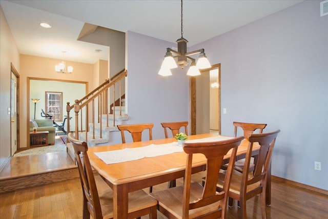 dining space with stairs, hardwood / wood-style flooring, a notable chandelier, and visible vents