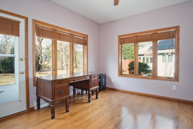 office space with baseboards and light wood finished floors