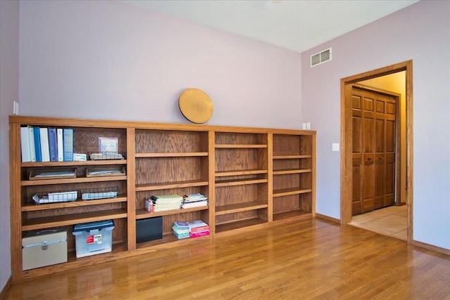 interior space with wood finished floors, visible vents, and baseboards