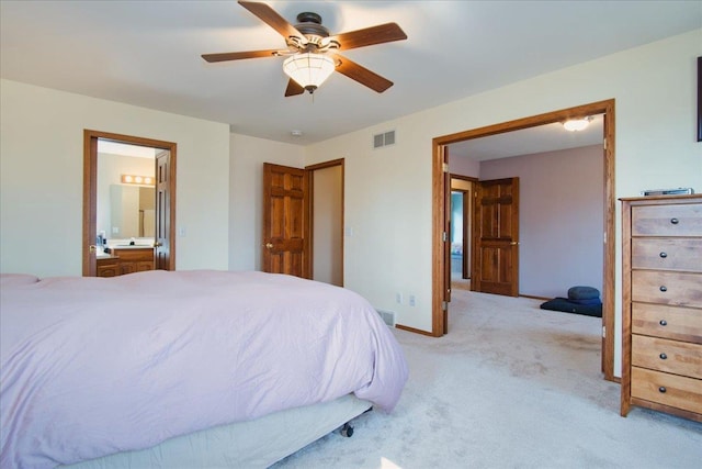 bedroom with visible vents, connected bathroom, baseboards, ceiling fan, and light colored carpet