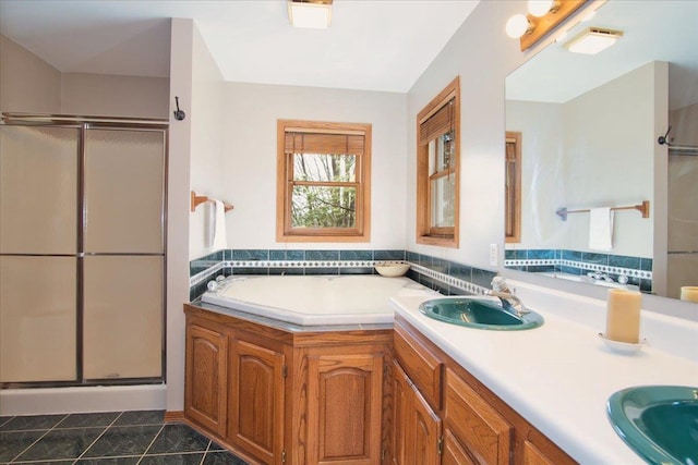 full bathroom with tile patterned flooring, a shower stall, a garden tub, and a sink