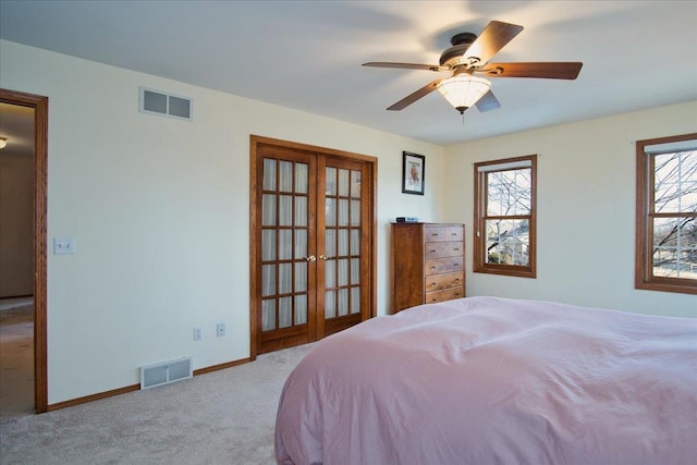 carpeted bedroom with visible vents, baseboards, a ceiling fan, and french doors