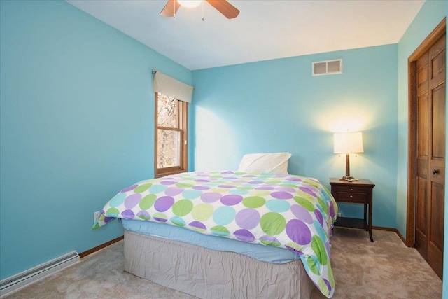 carpeted bedroom with visible vents, a ceiling fan, baseboards, and a baseboard radiator