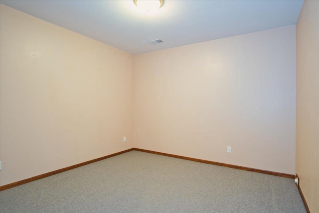 unfurnished room with carpet, visible vents, and baseboards