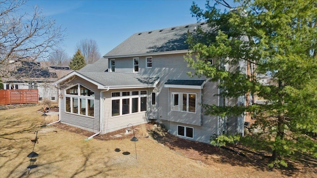 back of house with a shingled roof