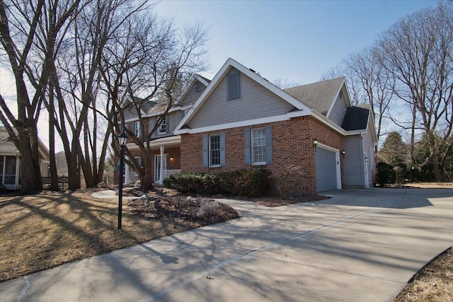 view of front facade with brick siding, an attached garage, and driveway