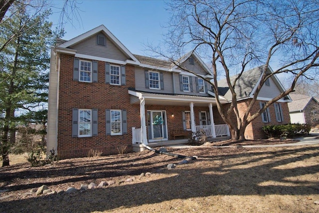 view of front of home with a porch and brick siding