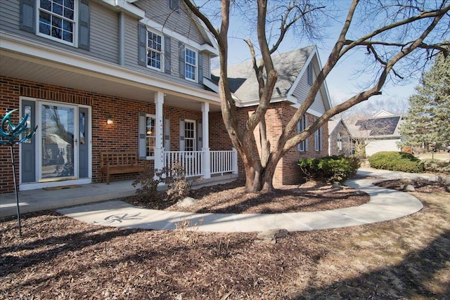 exterior space featuring a porch and brick siding