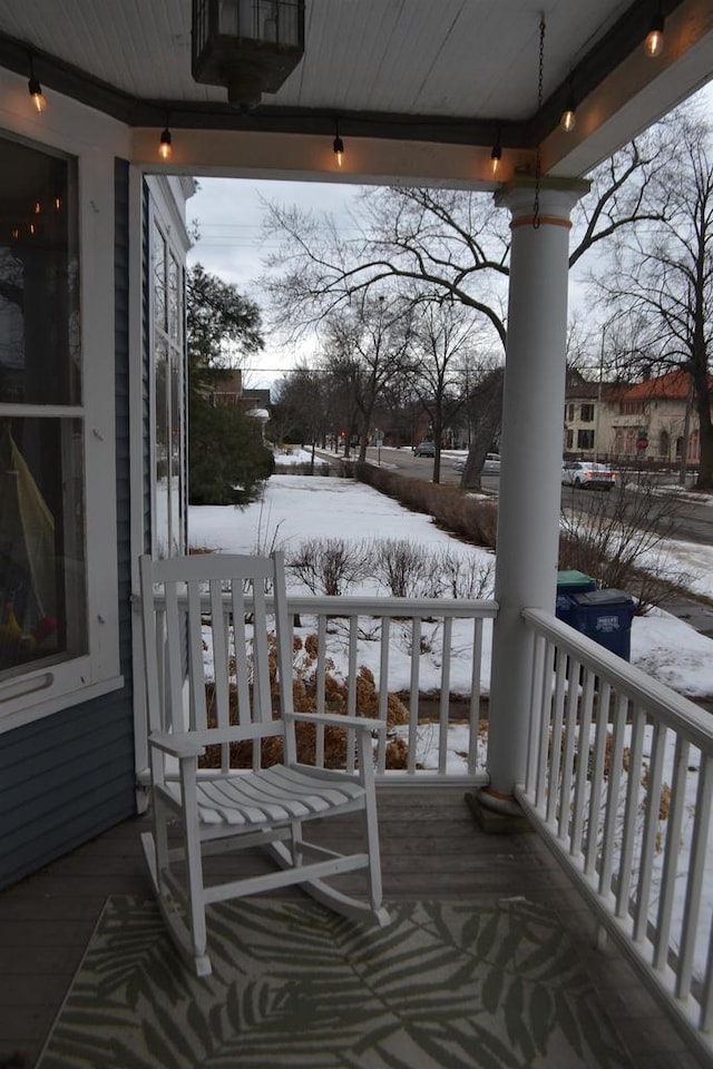 snow covered deck with a porch