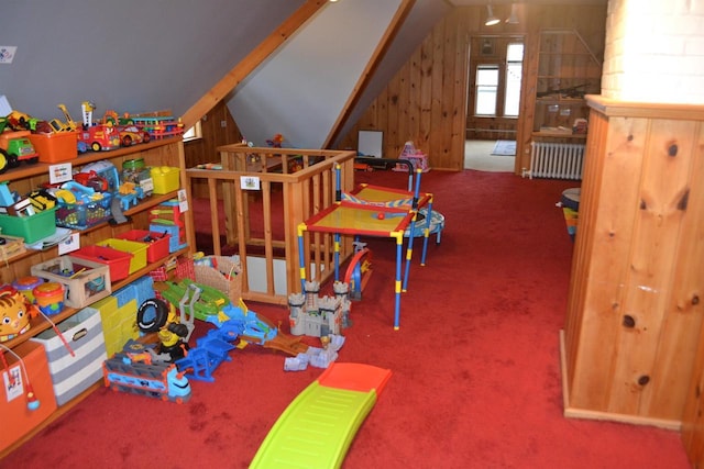 playroom featuring vaulted ceiling, carpet floors, and radiator