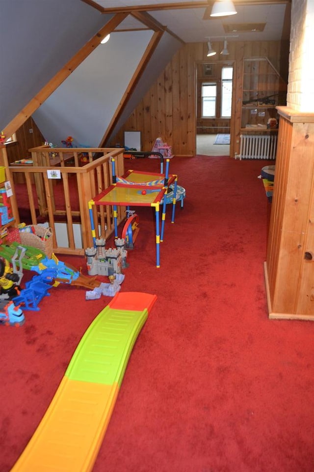 recreation room featuring radiator heating unit, vaulted ceiling, and carpet flooring