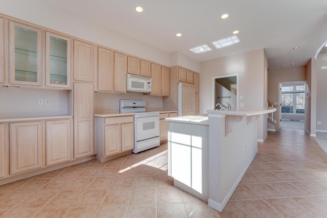 kitchen with light brown cabinets, recessed lighting, white appliances, and light countertops