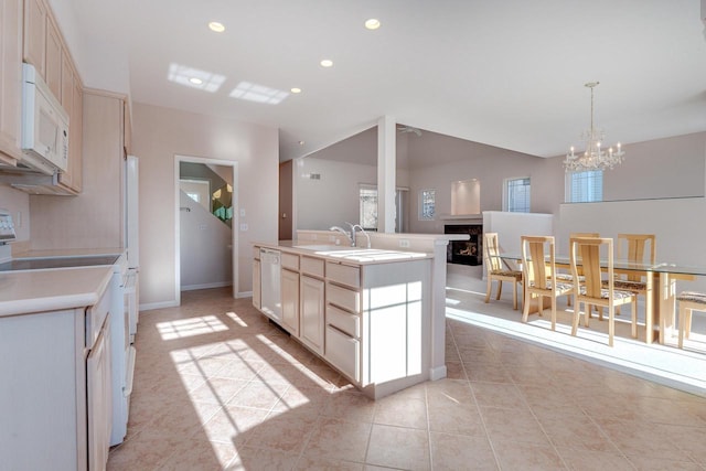 kitchen with a center island with sink, light countertops, recessed lighting, a fireplace, and white appliances