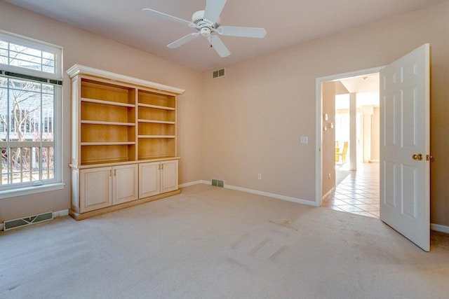 spare room featuring visible vents, light colored carpet, and plenty of natural light