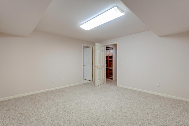 interior space with baseboards and light carpet