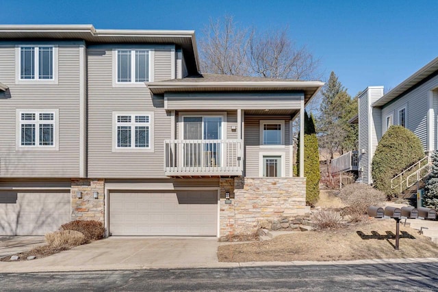 view of front of home featuring concrete driveway, a garage, and stone siding