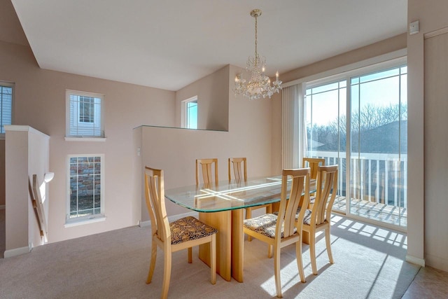 dining area with light carpet and a chandelier