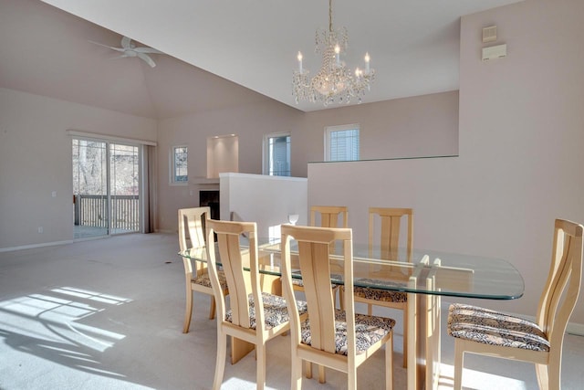 carpeted dining area with a fireplace, lofted ceiling, ceiling fan with notable chandelier, and baseboards