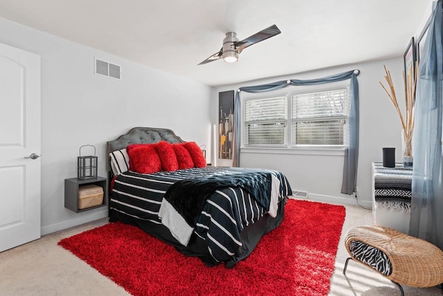 carpeted bedroom featuring ceiling fan, visible vents, and baseboards