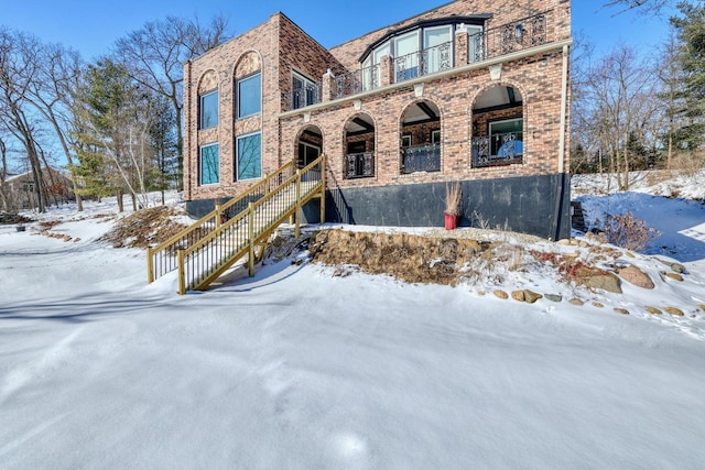 view of front of property with a balcony and brick siding