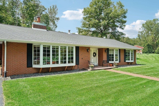 ranch-style house with a front yard, brick siding, and a shingled roof