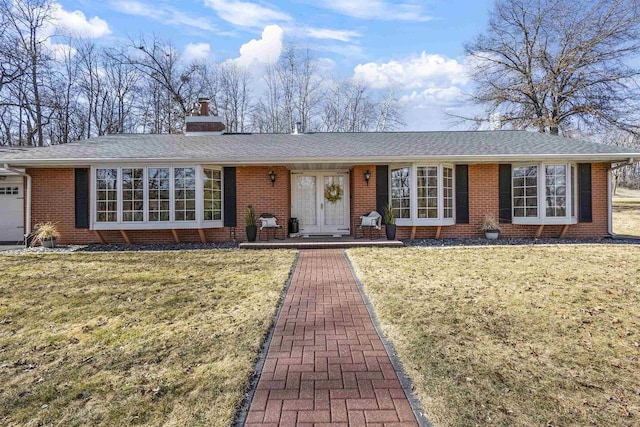 single story home with brick siding, a front lawn, and a chimney