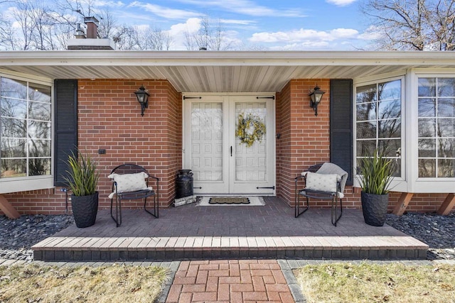 entrance to property with brick siding and covered porch