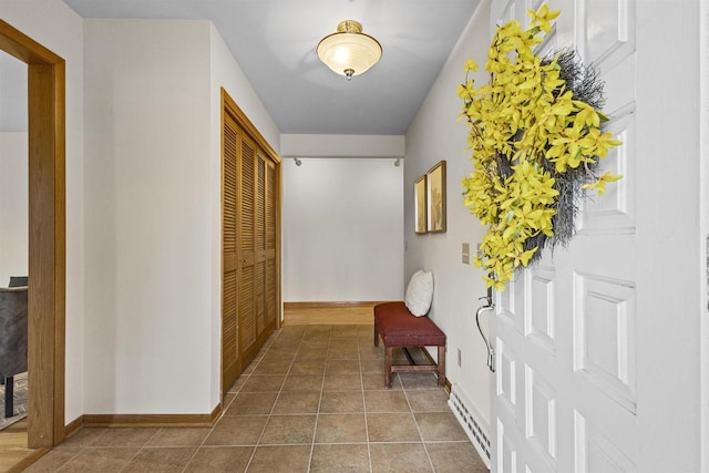 hall with tile patterned flooring, baseboards, and baseboard heating