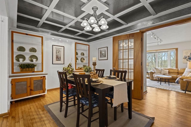 dining room featuring hardwood / wood-style floors, baseboards, coffered ceiling, an inviting chandelier, and track lighting