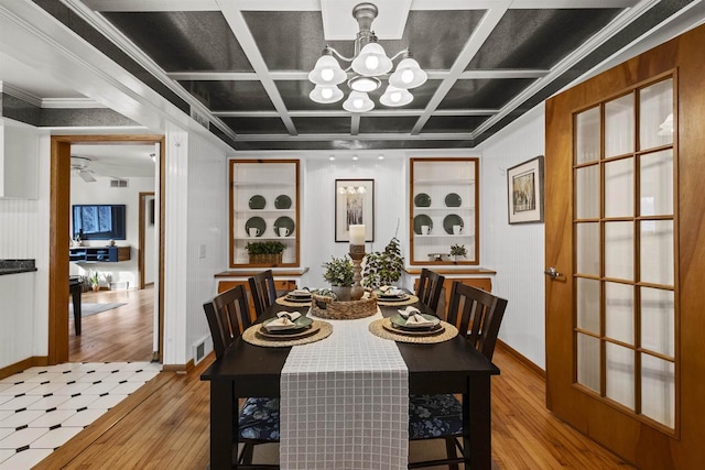 dining room featuring wood finished floors, visible vents, coffered ceiling, an inviting chandelier, and ornamental molding