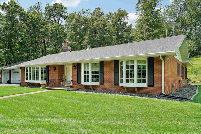 single story home with a front yard, roof with shingles, a chimney, a garage, and brick siding