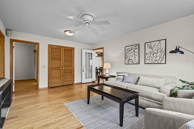 living room featuring light wood-type flooring and ceiling fan