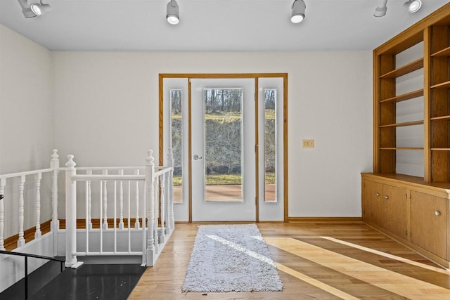 entryway with baseboards and wood finished floors