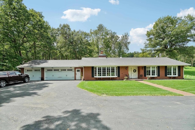 ranch-style home with a garage, driveway, brick siding, and a front yard