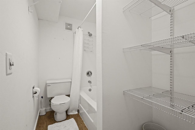 bathroom with visible vents, toilet, wood finished floors, and shower / tub combo with curtain