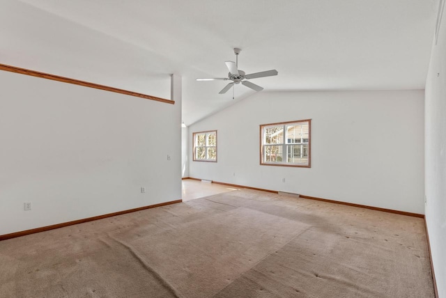 carpeted empty room with ceiling fan, baseboards, and vaulted ceiling