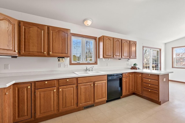 kitchen featuring a sink, dishwasher, a peninsula, and brown cabinetry