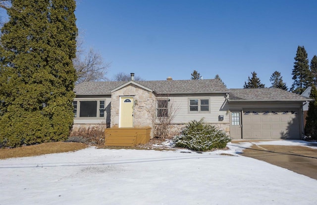 view of front of property with a garage, stone siding, a shingled roof, and driveway