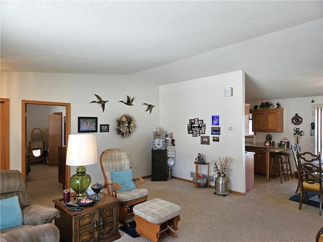 living area featuring vaulted ceiling, a textured ceiling, baseboards, and light colored carpet