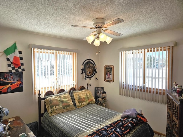 bedroom with ceiling fan and a textured ceiling