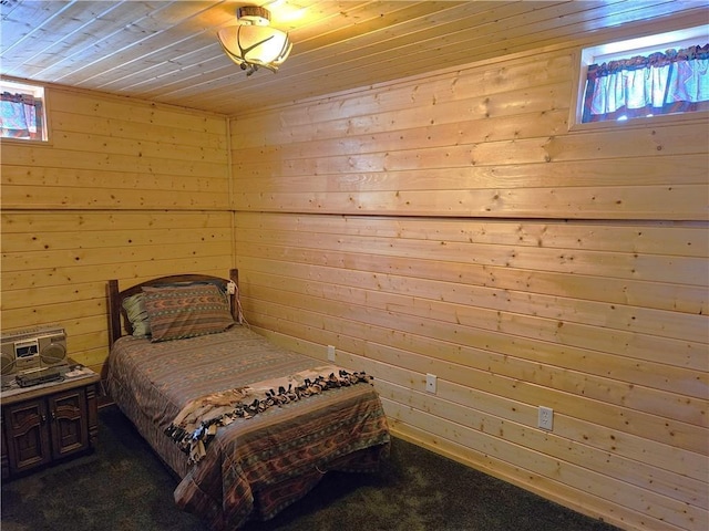 bedroom featuring wood walls, wood ceiling, and dark colored carpet