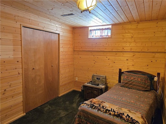 bedroom featuring wooden ceiling, a closet, carpet flooring, and wood walls