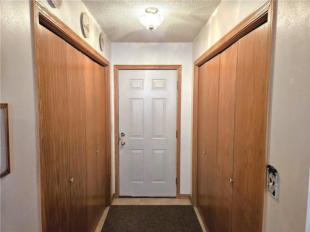 doorway to outside with a textured ceiling