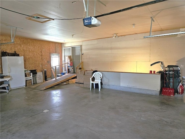 garage featuring a garage door opener and freestanding refrigerator