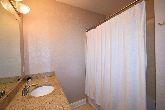 full bathroom featuring shower / tub combo, vanity, a textured wall, and tile patterned floors