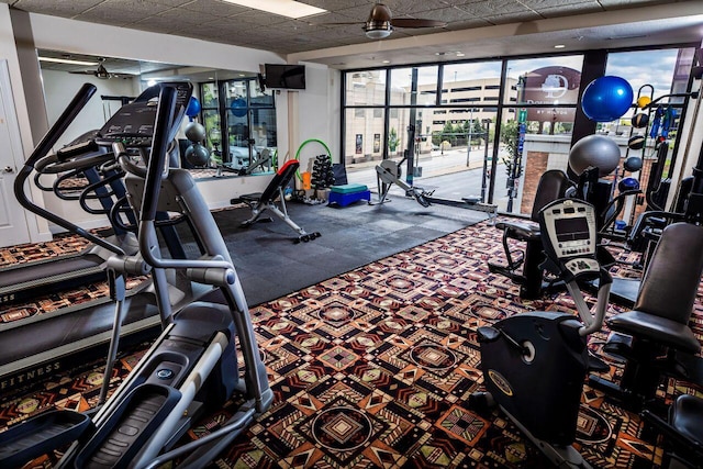 exercise room featuring a paneled ceiling and a ceiling fan