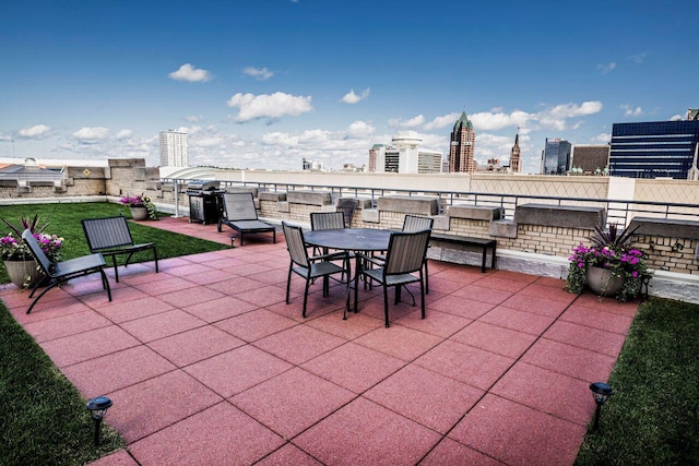 view of patio / terrace featuring a grill, a view of city, and outdoor dining space