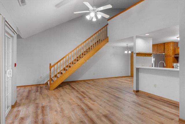 unfurnished living room with ceiling fan, visible vents, baseboards, stairway, and light wood finished floors