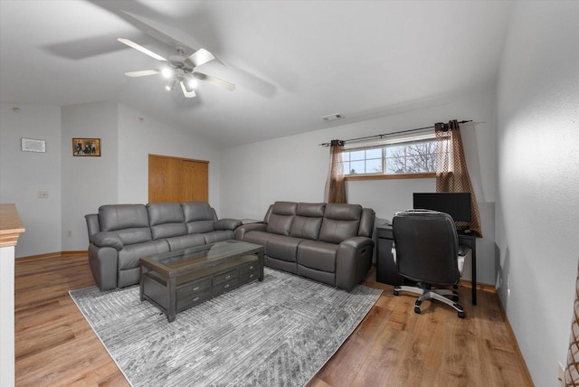 living room with lofted ceiling, visible vents, a ceiling fan, wood finished floors, and baseboards