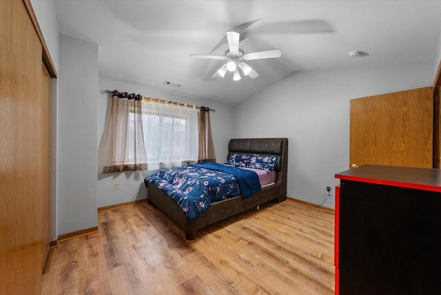 bedroom with visible vents, vaulted ceiling, light wood-style flooring, and baseboards